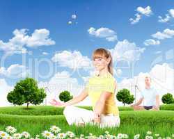 Young woman doing yoga against blue sky