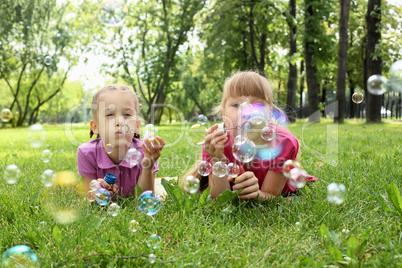 Little girl in the park blowing bubbles