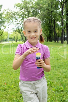 Little girl in the park blowing bubbles