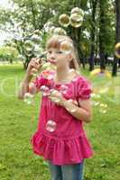 Little girl in the park blowing bubbles