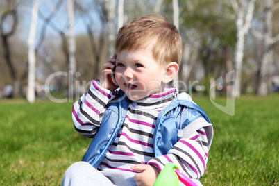 litlle boy with mobile in the park