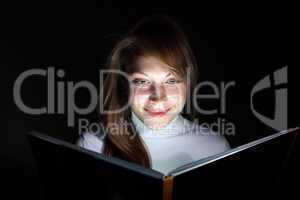 Young woman reading a magic book