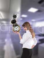businesswoman in office holding clock pyramid