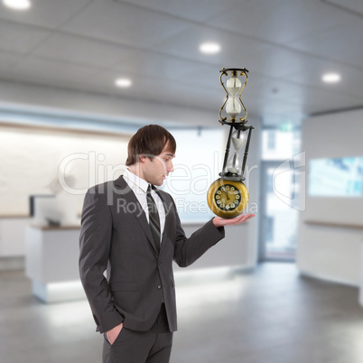 businessman in office holding clock pyramid