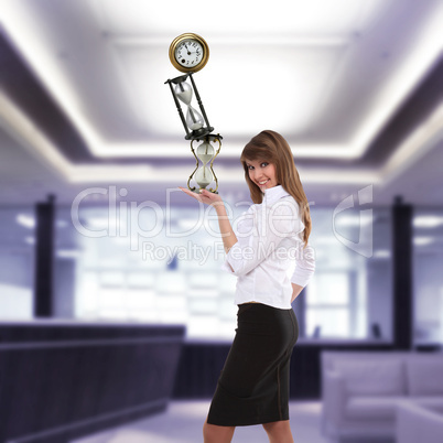 businesswoman in office holding clock pyramid