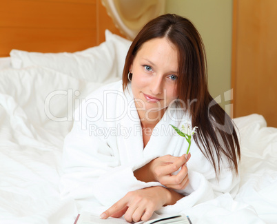 young woman in bed reading a book