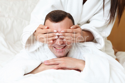 man with eyes closed by his girlfriend's hands