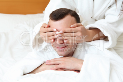 man with eyes closed by his girlfriend's hands