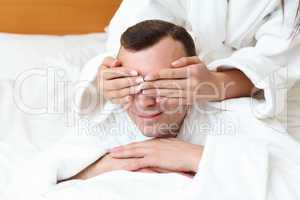 man with eyes closed by his girlfriend's hands
