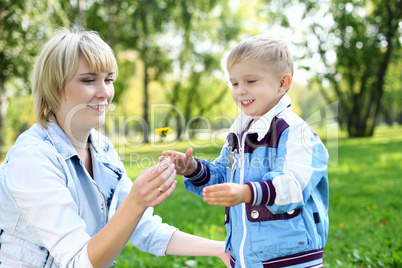 Young mother with her son in summer park