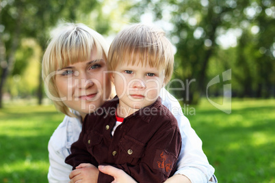 Young mother with her son in summer park