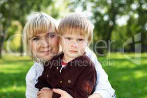 Young mother with her son in summer park