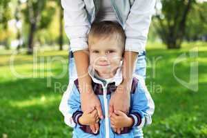 Young mother with her son in summer park