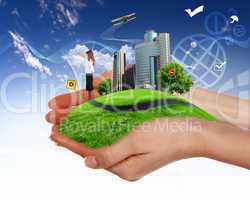 human hand holding a green city