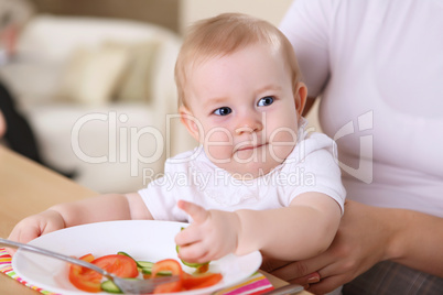 baby eating with parents at home