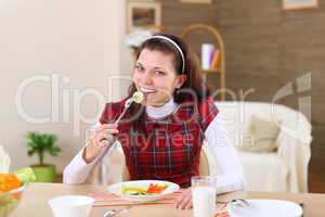 young girl eating healthy food at home