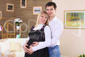 young pregnant woman with her husband at home