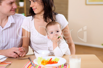 baby eating with parents at home