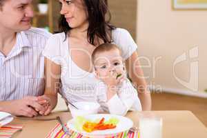 baby eating with parents at home