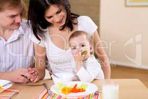 baby eating with parents at home