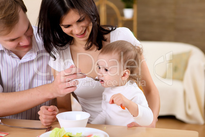 baby eating with parents at home