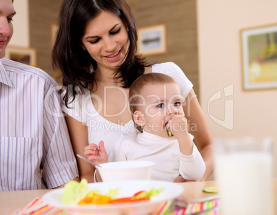 baby eating with parents at home