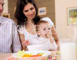 baby eating with parents at home
