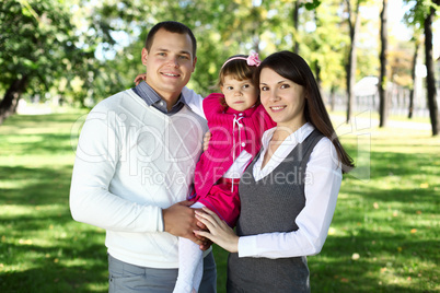 Young family with a child in summer park