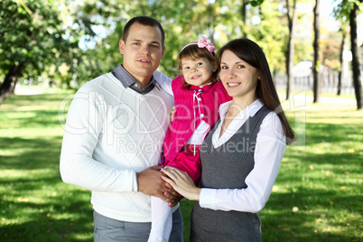 Young family with a child in summer park