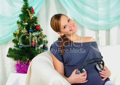 Pregnant woman holding headphones