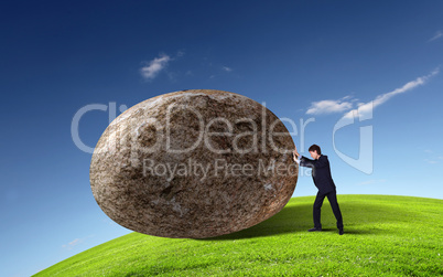 Businessman rolling a giant stone