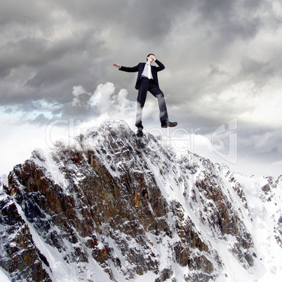 Businessman on the top of a high mountain