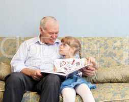 grandfather and granddaughter reading book