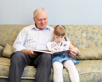 grandfather and granddaughter reading book