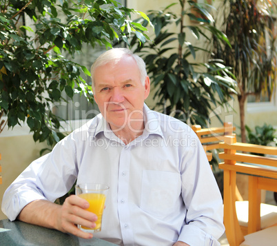portrait of old man with orange juice