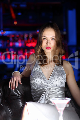 Young woman in night club with a drink