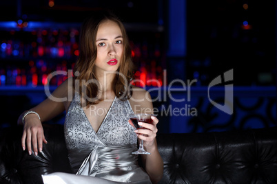 Young woman in night club with a drink