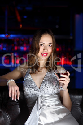 Young woman in night club with a drink