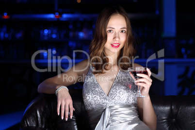 Young woman in night club with a drink