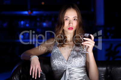 Young woman in night club with a drink