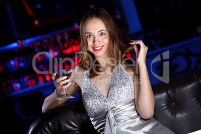 Young woman in night club with a drink