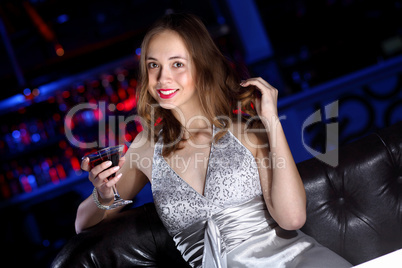 Young woman in night club with a drink