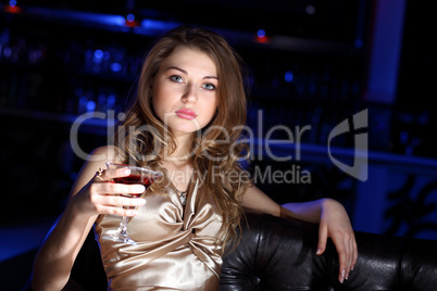 Young woman in night club with a drink