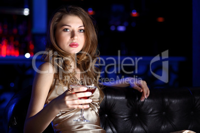 Young woman in night club with a drink