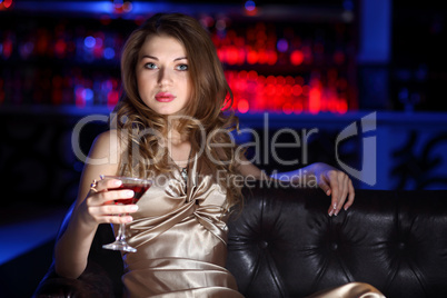 Young woman in night club with a drink