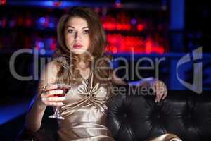 Young woman in night club with a drink