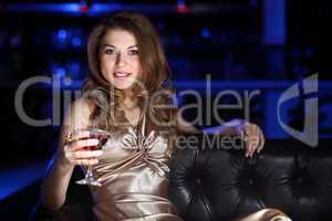 Young woman in night club with a drink