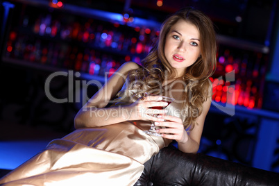 Young woman in night club with a drink