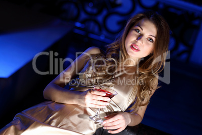 Young woman in night club with a drink