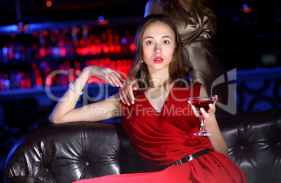 Young woman in night club with a drink